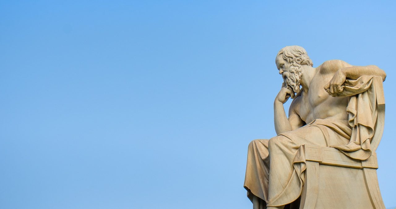 Ancient marble statue of the great Greek philosopher Socrates against a background of blue sky
